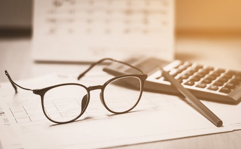 Eine Brille neben einem Taschenrechner